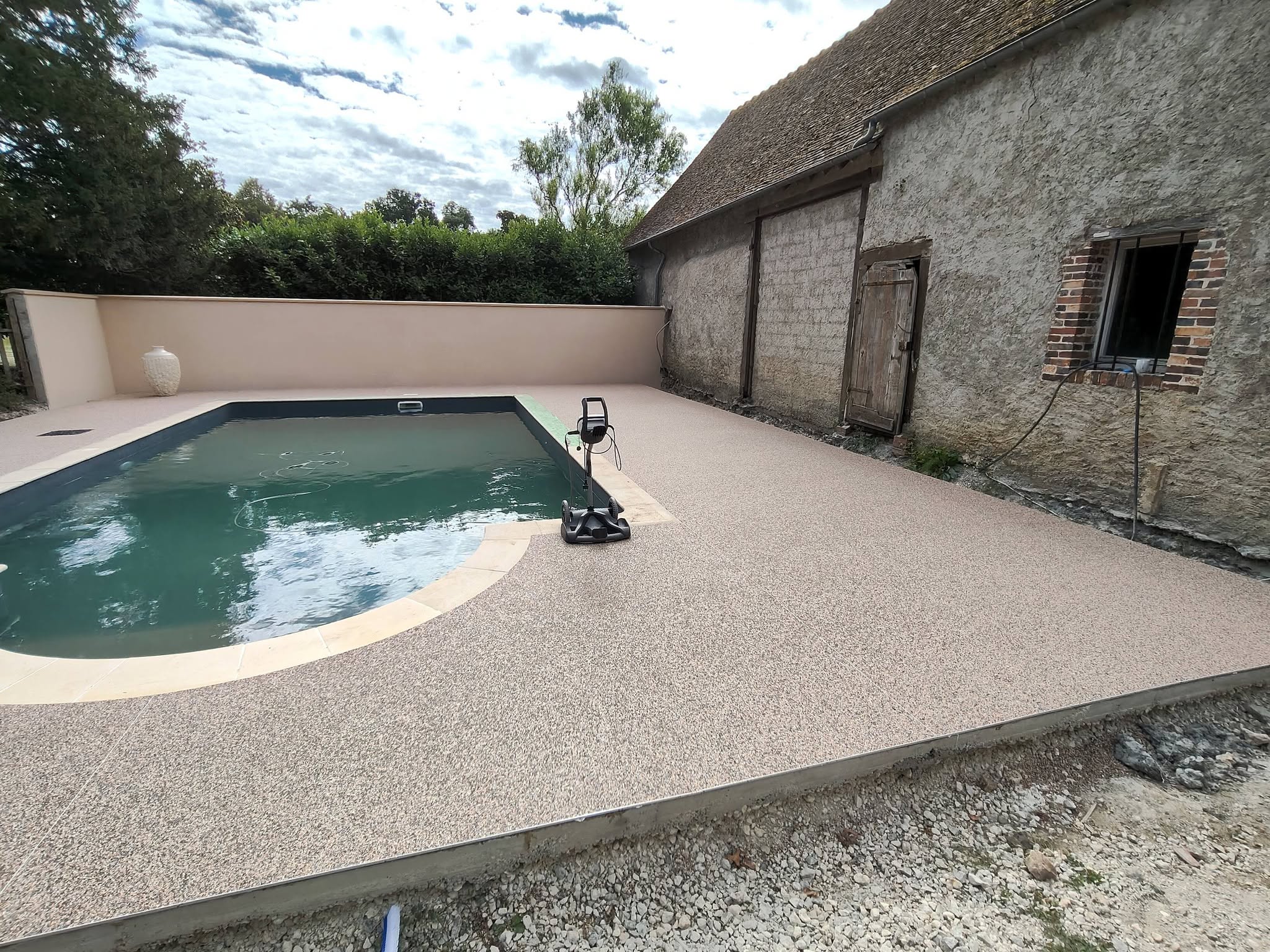 Piscine avec moquette de pierre naturelle posée par FTC aux Villages Vovéens